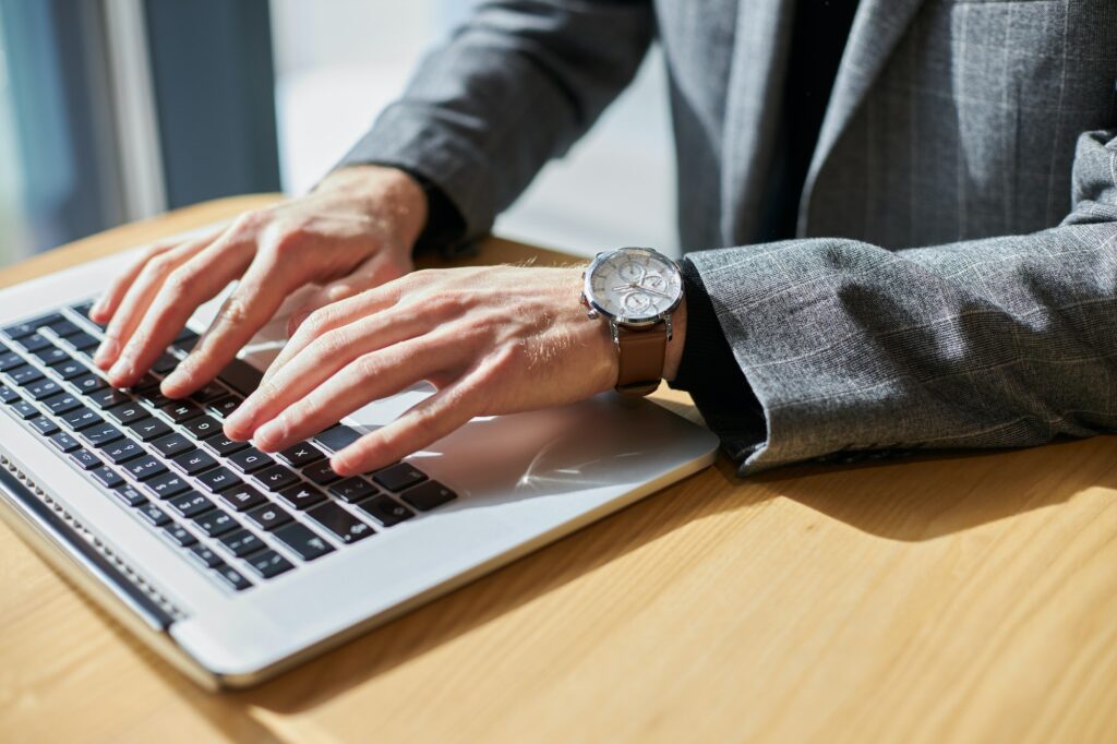 Copywriter hands using laptop, typing on keyboard working freelance project online, selective focus