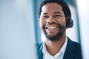 Customer support, black man and call center consultant speaking to an online client with a headset.