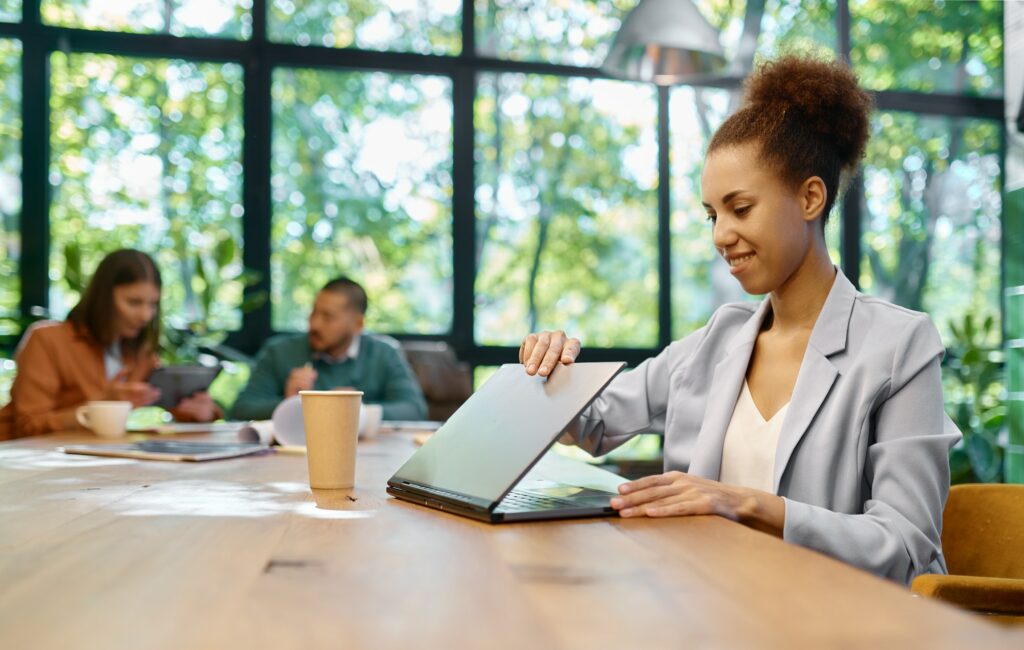 Young business woman working on laptop at shared open workspace