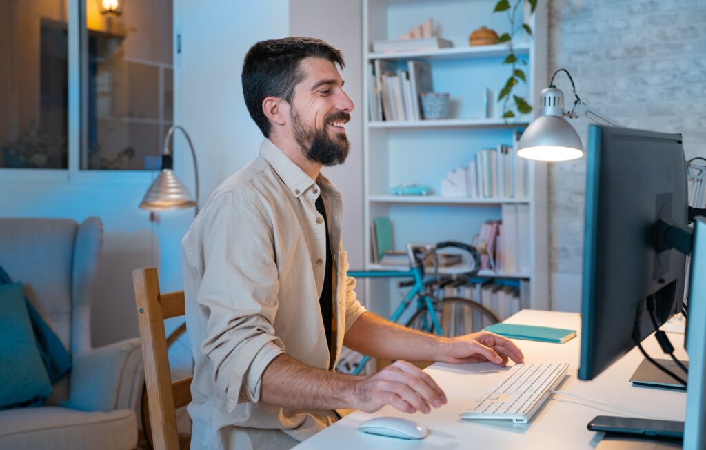 Young creative entrepreneur happy smiling while working in his modern workspace at home.