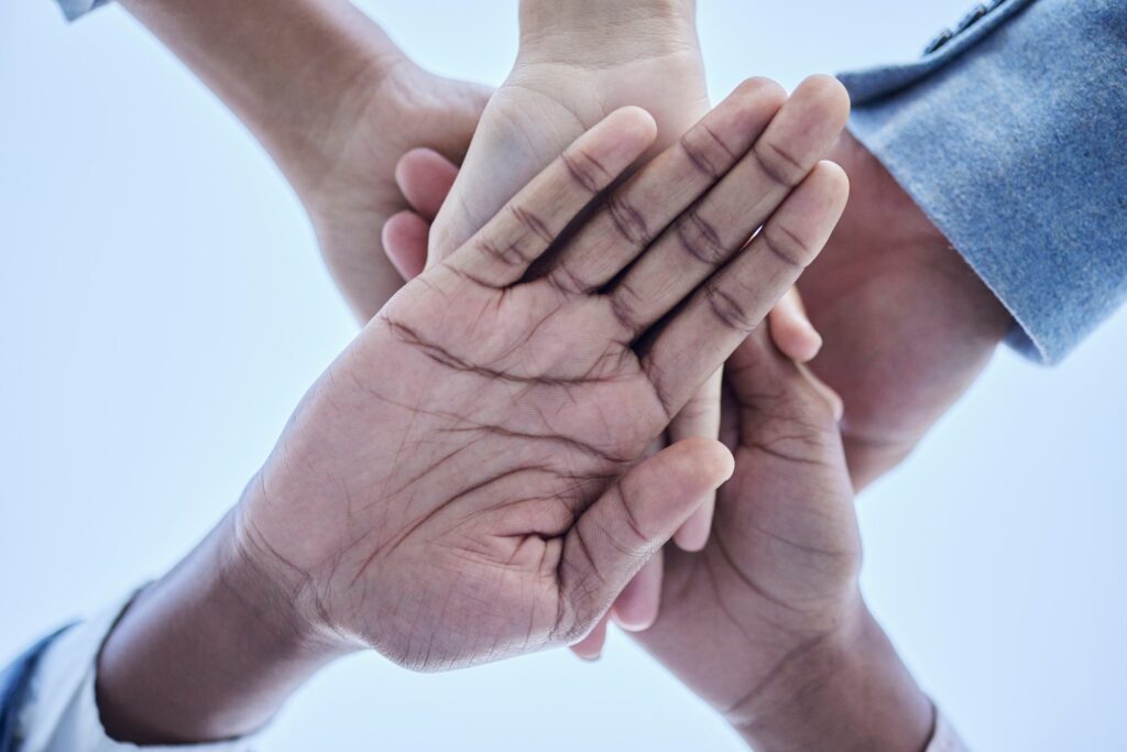 People, trust and hands together below for community, unity or team agreement in support for collab